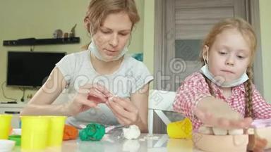 一个年轻的女人和一个女孩用塑料制成<strong>牙齿</strong>，把<strong>牙齿</strong>插入玩具下巴，扮演一个牙医，母亲和